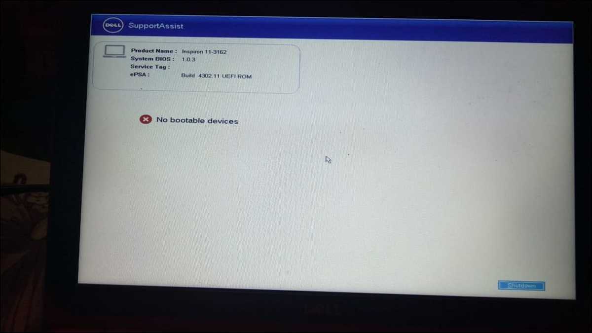 Photo of a Dell laptop screen displaying the "No bootable devices found" error message in a real setting (desk, slightly dim)